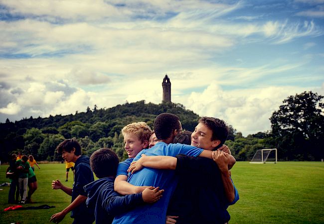 ISSFT students hugging with the Wallace Monument in the distance