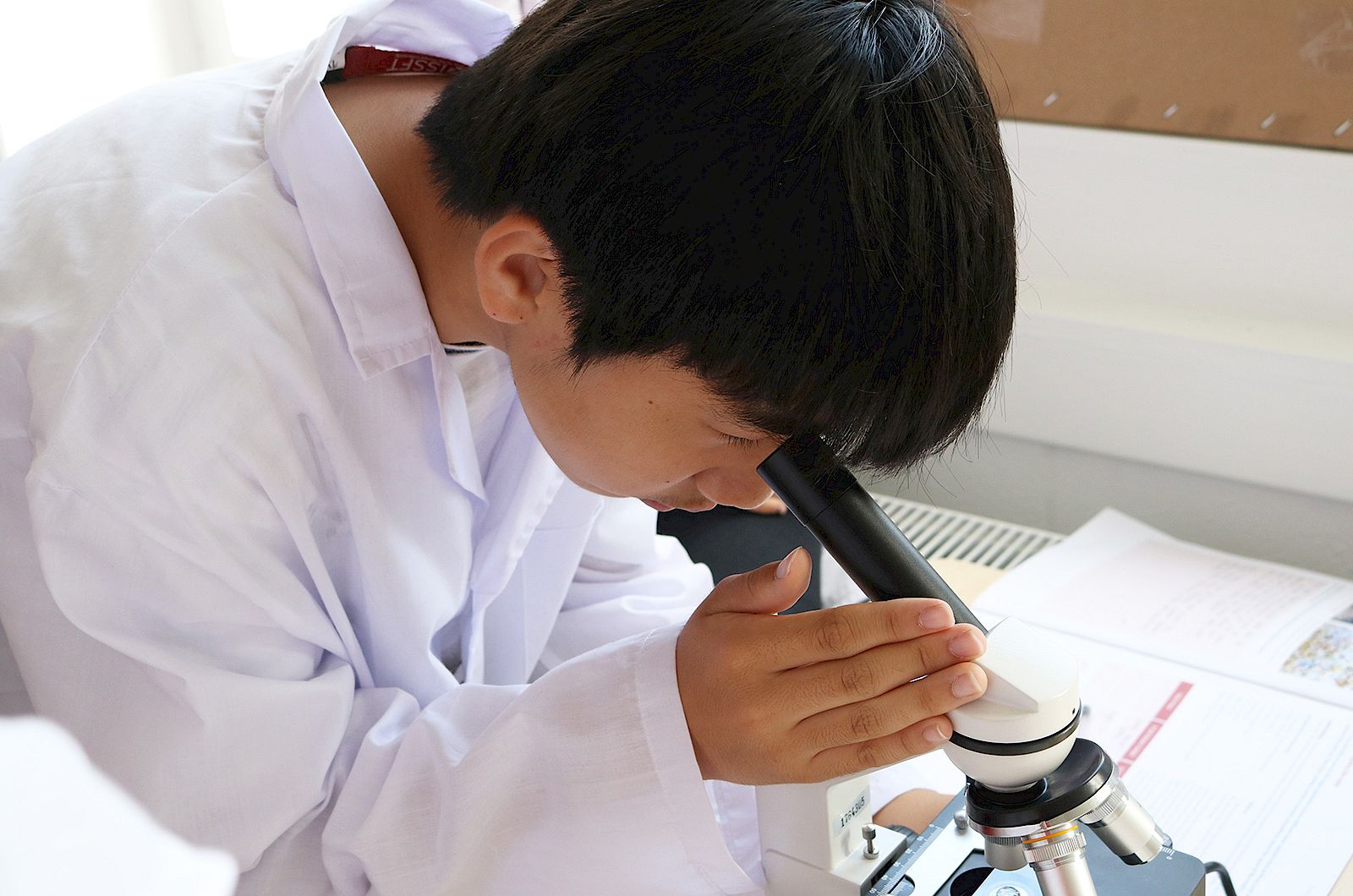 ISSFT student looking into a microscope