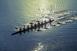 8 rowers in one rowing boat gliding down a river