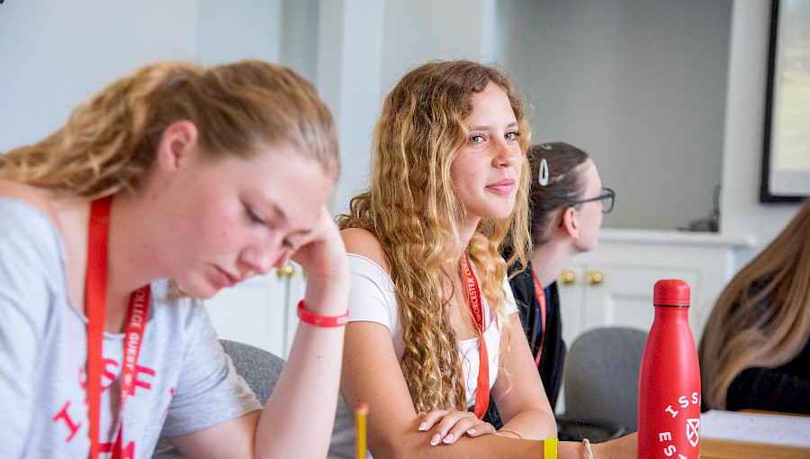 female summer school student sitting at a desk with and issft bottle on table